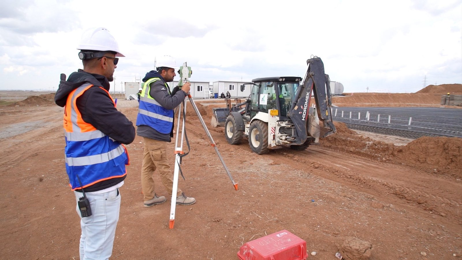 KATO surveying team and a backhoe at the construction site
